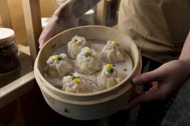 Man holding tray of dumplings