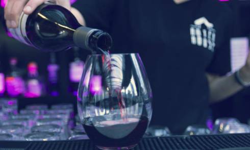 Hand pouring wine into a glass