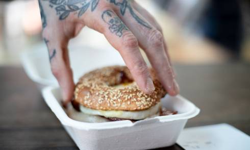 Hand placing the top of a bagel
