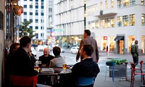 People sitting at tables on the pathway