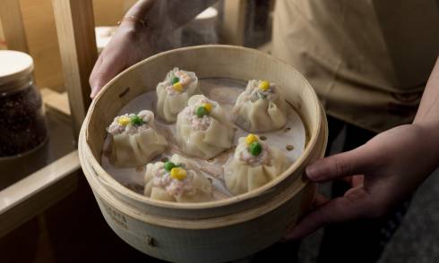 Man holding tray of dumplings
