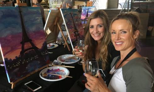 People drinking wine and painting 