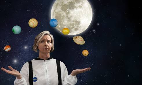 Woman in a space suit juggles planets with the moon in the background